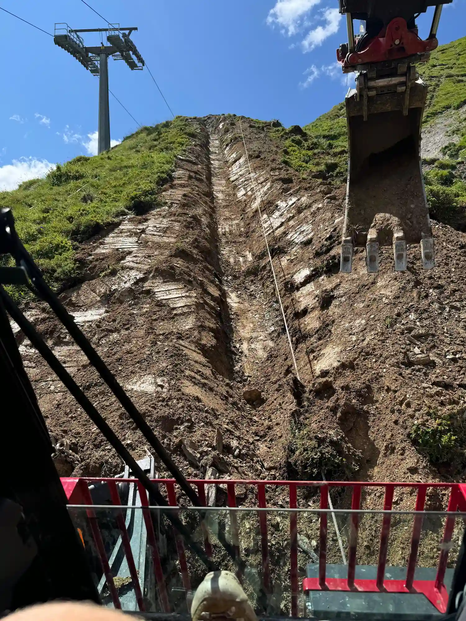 Der Schreitbagger von der Firma Schreitbagger Gstrein in steilem Gelände beim Baggern von Furchen für Leitungen.